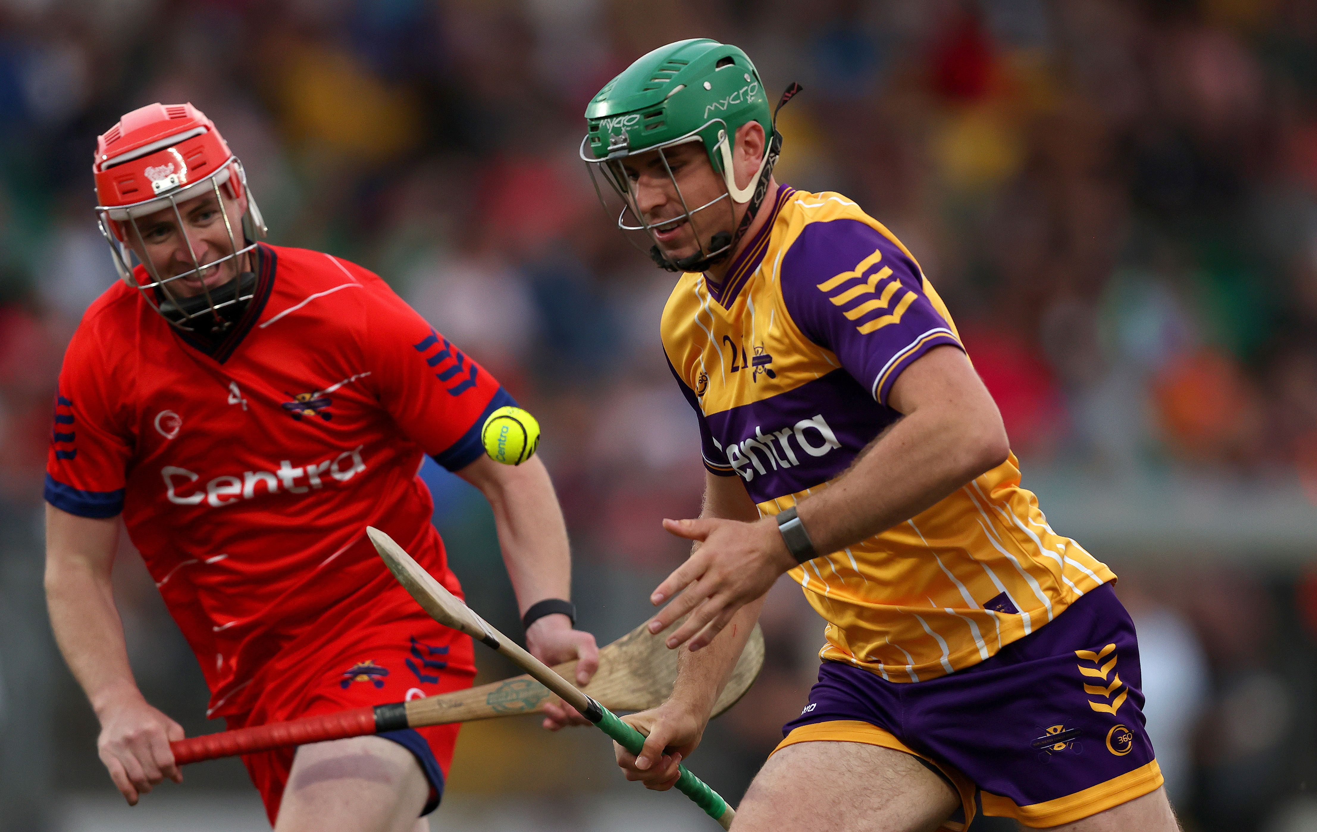 2 man playing hurling in with a blurred background