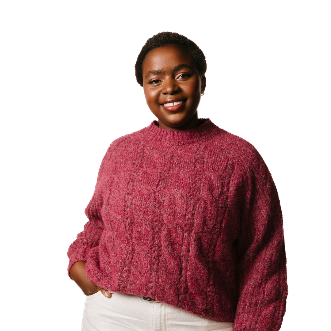 A young woman with short dark hair. She is smiling at the camera and is wearing a pink jumper.