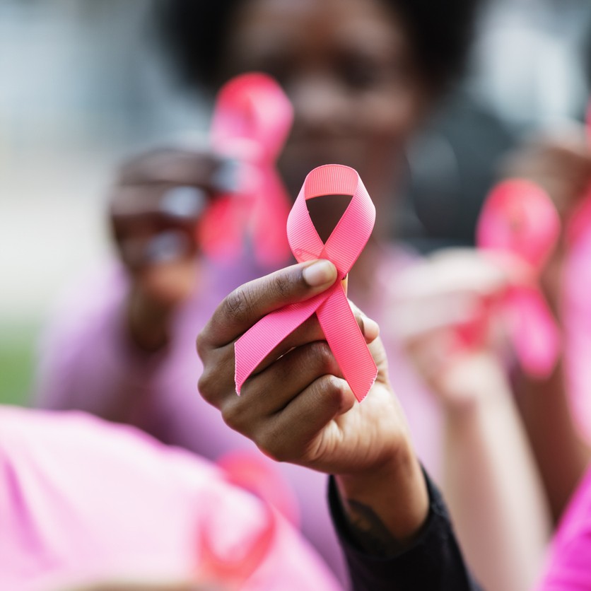Women holding pin ribbons to the camera