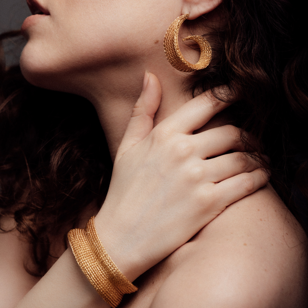 A lady wearing a woven bracelet and earring.