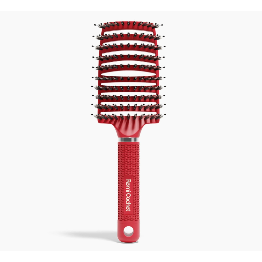 A red hair brush with white writing that says 'Remi Catchet' on it.