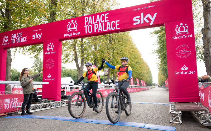 Two cyclists crossing the Palace to Palace finish line