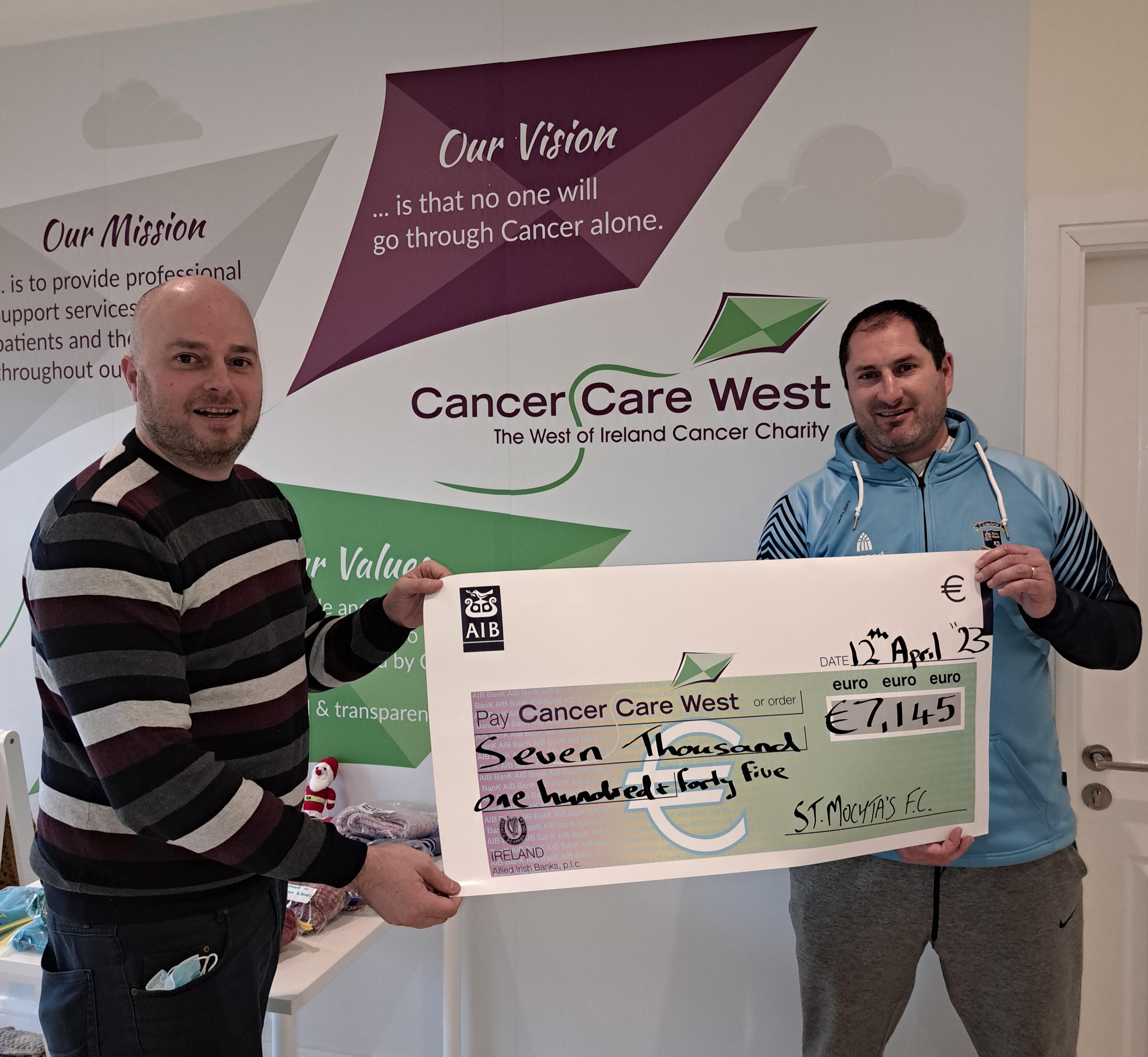 Colin with a cheque for Cancer Care West